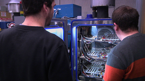 Zwei Mitarbeiter uberprüfen ein Batteriepack in einem Klimaschrank